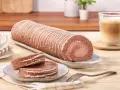 Eine köstliche schoko biskuitrolle mit weißer Glasur, dane zwei Scheiben und ein Kaffee.