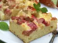 Saftiger Rhabarberkuchen mit cremiger Füllung, perfekt für Rhabarber Rezepte. Mit Minze garniert.