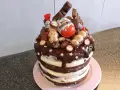 Schokoladentorte mit Kinder-Überraschungsei, Schoko-Bons und vielen weiteren Süßigkeiten dekoriert.