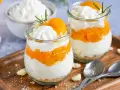 Zwei Gläser mit einem schnellen Dessert aus Mandarinen und Sahne, garniert mit Rosmarin.