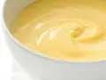 Cremige, gelbe Crema Pasticcera in einer weißen Schüssel, die zum Genuss einlädt.