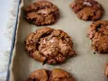 Saftige schoko cookies mit Meersalzflocken auf Backpapier, bereit zum Genießen.