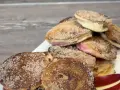 Ein Haufen goldbrauner, mit Zimt und Zucker bestreuter Apfelküchlein, die köstlich aussehen.