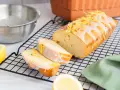 Ein saftiger Zitronenkuchen, frisch aus dem Ofen, mit Zuckerguss und Zitronenschale verziert. Perfekt für ein Zitronenkuchen Rezept.