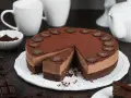 Eine köstliche Schoko Torte, bestäubt mit Kakao und verziert mit Schokoladensternen und -hirschen. Ein Stück ist bereits angeschnitten.