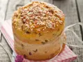 Ein goldbrauner Panettone mit Rosinen und Zuckerkristallen, gebunden mit einem Satinband. Ein köstliches Panettone Rezept zum Nachbacken.