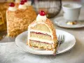 Ein Stück Frankfurter Kranz mit Buttercreme und Kirschen, umhüllt von gehackten Nüssen. Ein Genuss für jeden Kaffeetisch.