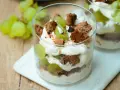 Cremiges Dessert im Glas mit grünen Trauben und zerbröselten Keksen. Ein süßer Genuss, der an einen Trauben-Keks-Traum erinnert.
