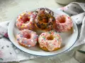 Sechs bunte Donuts auf einem Teller, perfekt für ein schnelles Donuts Rezept. Mit Streuseln und Sternen verziert.