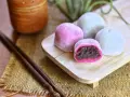 Bunte Mochi-Kugeln mit roter Bohnenpaste, bereit zum Genießen. Perfekt, um Mochi selber machen zu lernen und diese Leckereien zu kreieren.