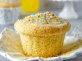 Ein Fanta Muffin mit Zuckerguss und bunten Streuseln, bereit zum Genießen.