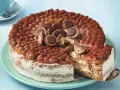 Eine köstliche Toffifee Torte, verziert mit Kakao und Toffifee-Pralinen, wird angeschnitten.