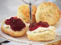 Zwei Scones mit Clotted Cream und Marmelade auf einer Etagere. Ein köstliches Rezept für Scones, perfekt für den Nachmittagstee.