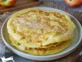 Ein Stapel goldbrauner Apfelpfannkuchen, bestäubt mit Puderzucker. Ein köstliches Apfelpfannkuchen Rezept für jeden Anlass.