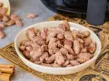 Schüssel voller gebrannter Mandeln, perfekt für ein schnelles gebrannte mandeln rezept. Zimtstangen liegen daneben.