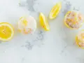 Erfrischende Zitronenmuffins mit Zuckerguss und Zitronenspalten. Ein tolles Rezept für zitronenmuffins!