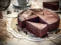 Ein saftiger, schneller Schokokuchen mit glänzender Glasur und einer Kuchenscheibe auf einem Tortenheber.