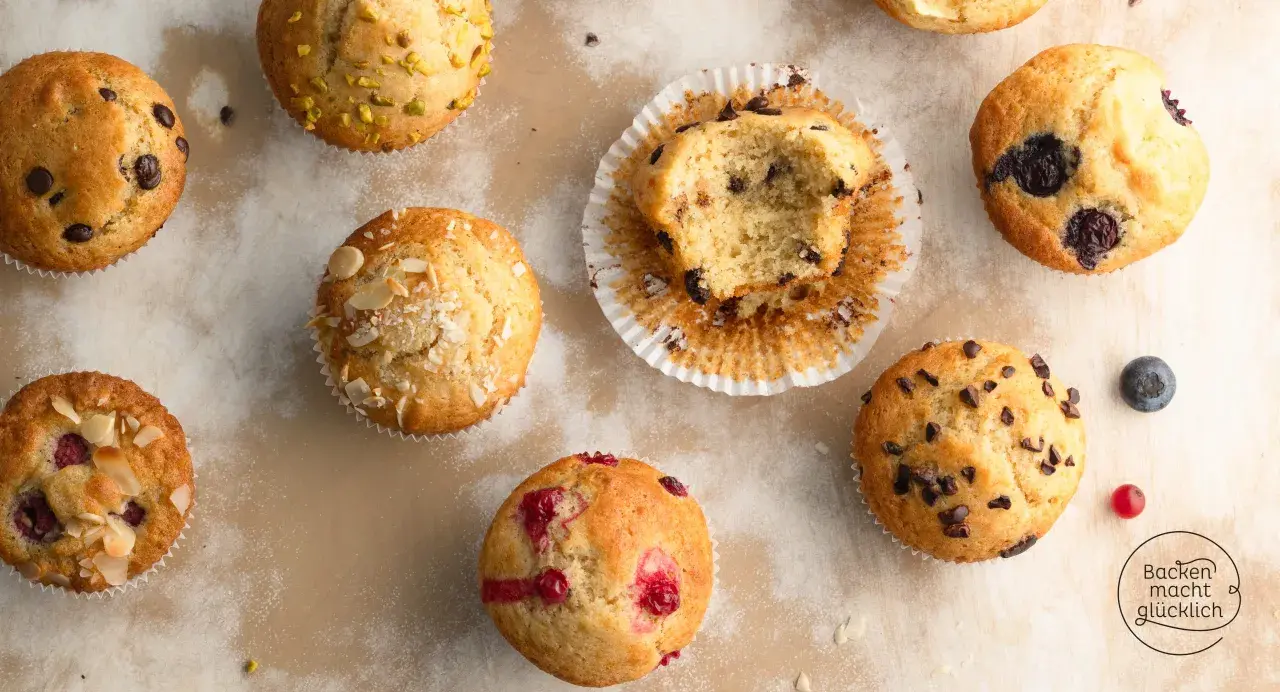 Verschiedene Muffins, perfekt für ein schnelles Muffins Rezept: Schoko, Blaubeer, Himbeer und Pistazien. Ein Bissen fehlt vom Schokomuffin.