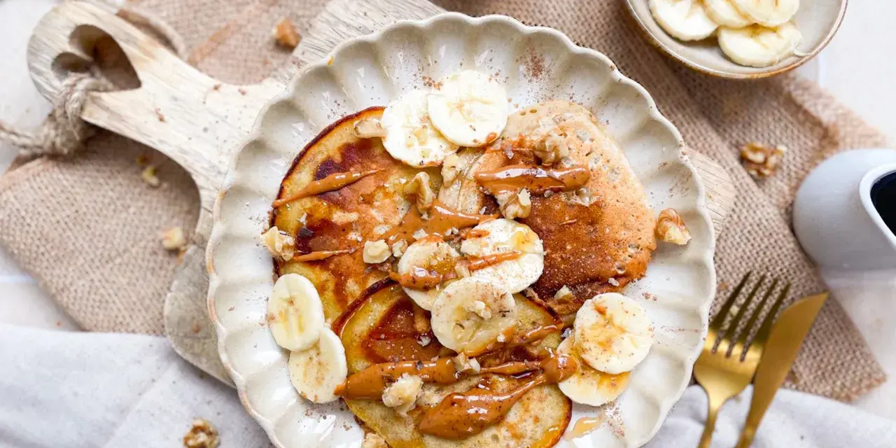 Leckere bananen pancakes ohne ei, garniert mit Bananenscheiben, Nüssen und einer cremigen Sauce. Ein Genuss für jeden Morgen!