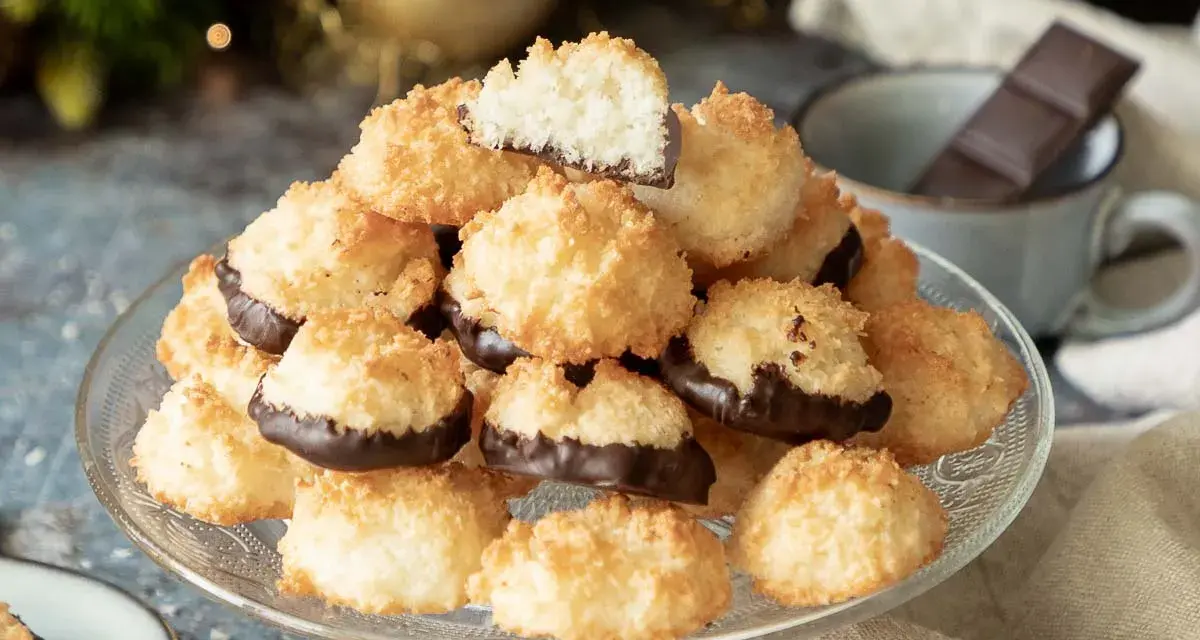 Ein Berg goldbrauner Kokosmakronen, die untere Hälfte in dunkle Schokolade getaucht. Perfekt für ein schnelles Kokosmakronen Rezept.