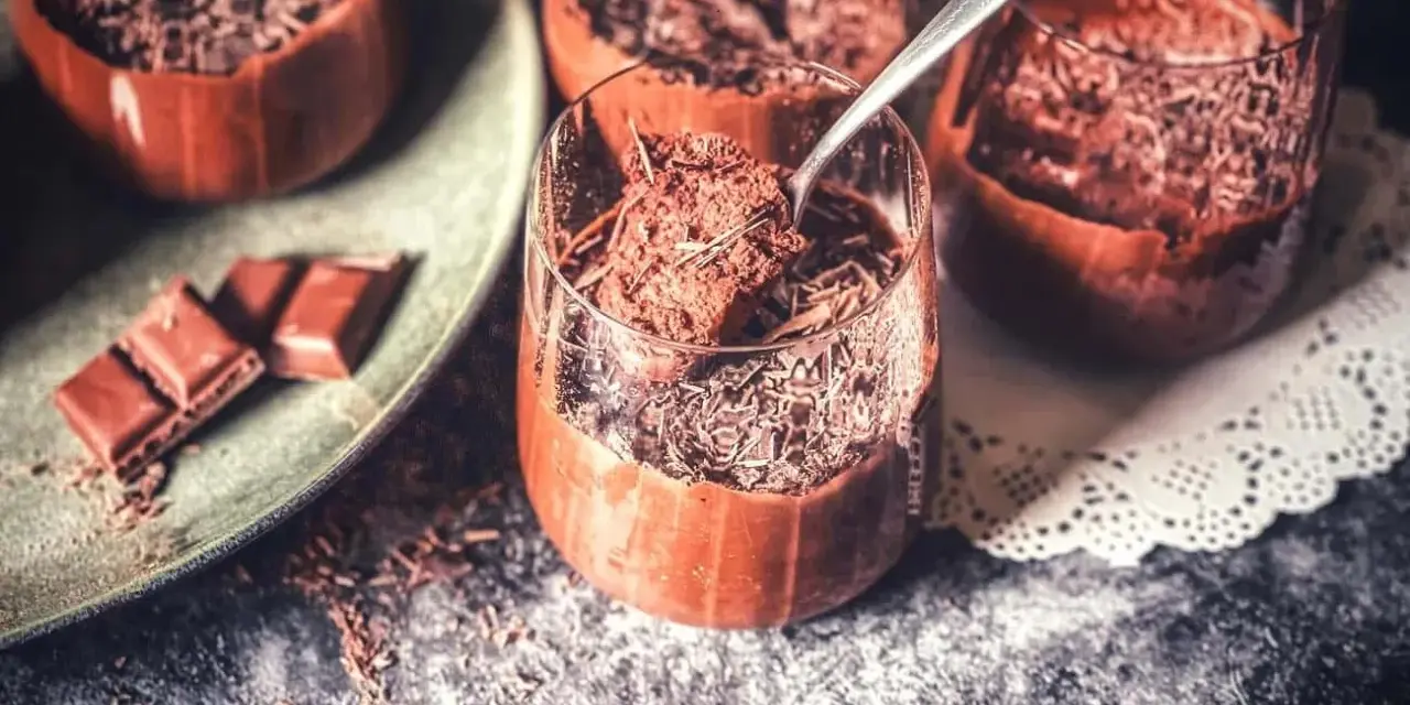 Lufterleichter Genuss: Mousse au chocolat ohne Ei, garniert mit Schokostreuseln. Ein Löffel zeigt die cremige Konsistenz.