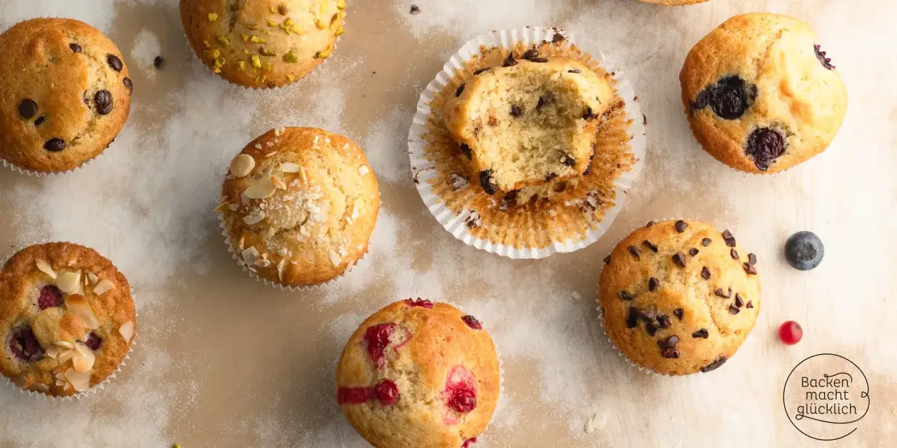 Verschiedene Muffins, perfekt für ein schnelles Muffins Rezept: Schoko, Blaubeer, Himbeer und Pistazien. Ein Bissen fehlt vom Schokomuffin.