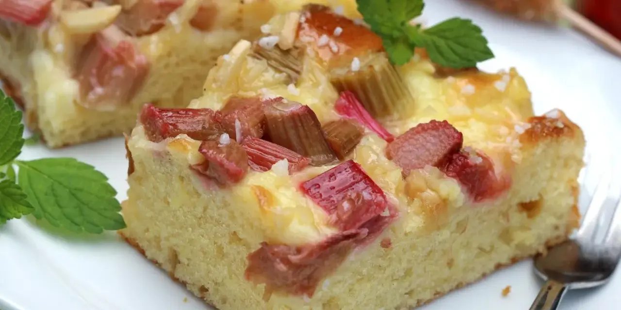 Saftiger Rhabarberkuchen mit cremiger Füllung, perfekt für Rhabarber Rezepte. Mit Minze garniert.