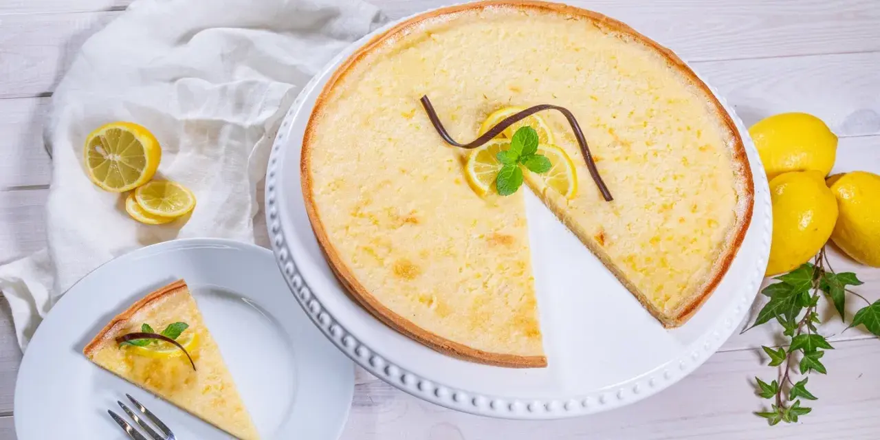 Ein Zitronentarte Rezept, das Lust auf mehr macht. Sonnengelbe Tarte mit frischen Zitronenscheiben und Minze.