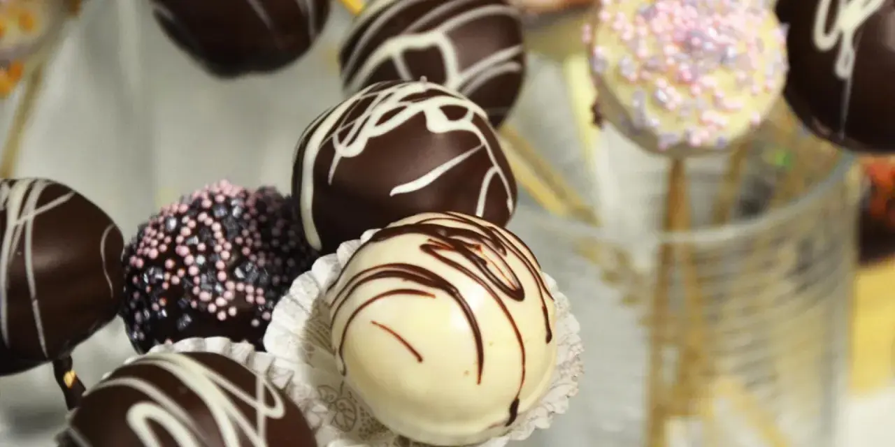 Bunte Kuchen am Stiel, dekoriert mit Schokolade und Streuseln, warten darauf, genascht zu werden.