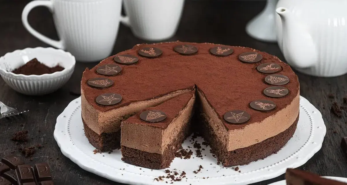 Eine köstliche Schoko Torte, bestäubt mit Kakao und verziert mit Schokoladensternen und -hirschen. Ein Stück ist bereits angeschnitten.