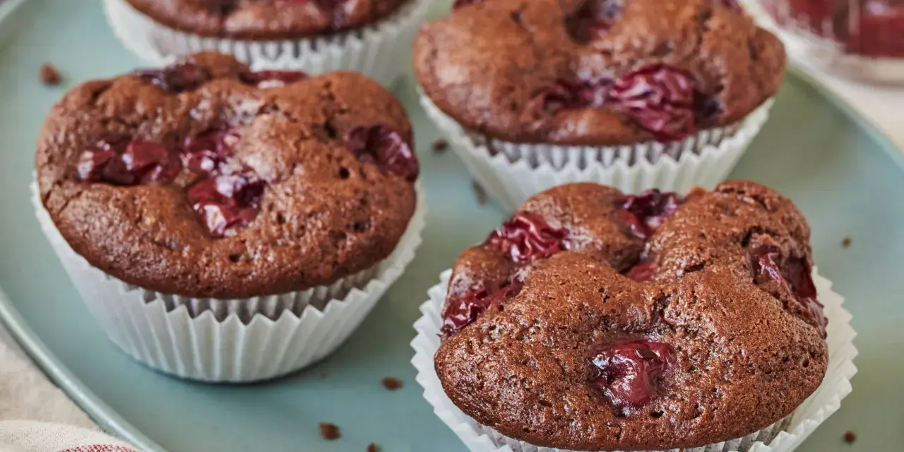 Saftige schoko kirsch muffins auf einem blauen Teller, bereit zum Genießen.