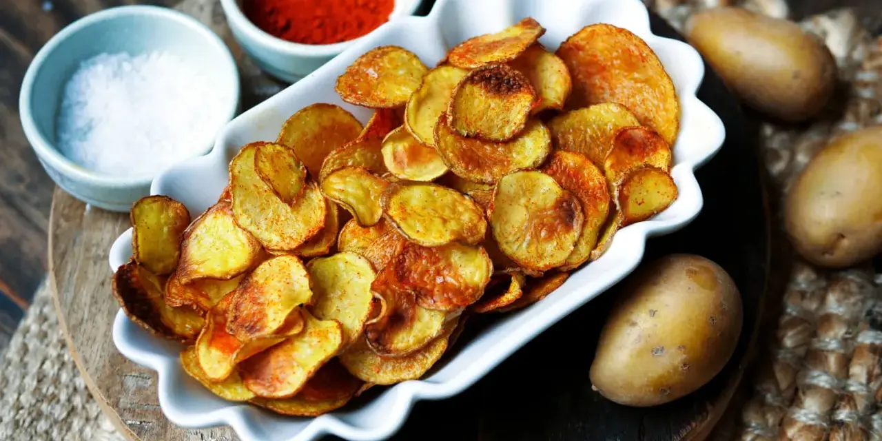 Selbstgemachte Kartoffelchips, goldbraun und knusprig, mit Salz und Paprikapulver gewürzt. So einfach ist kartoffelchips selber machen!
