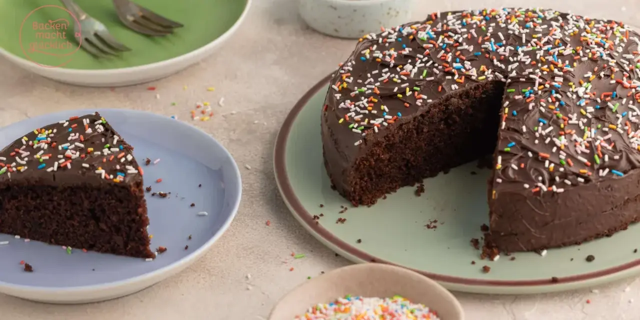 Ein saftiger Nutella Kuchen mit Schokoladenglasur und bunten Streuseln, ein Stück auf einem Teller, bereit zum Genießen.