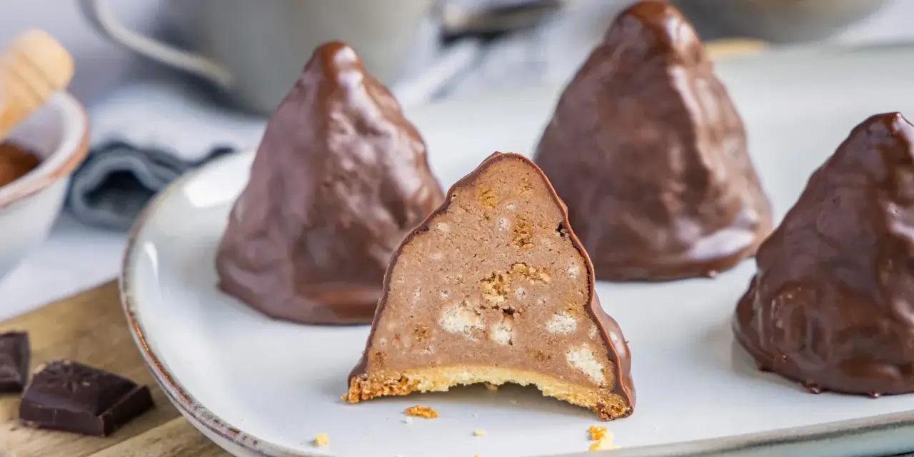 Schokoladen-Desserts, die an Granatsplitter erinnern, mit einem Stück, das die cremige Füllung mit Keksstücken zeigt. Ein köstliches granatsplitter rezept.