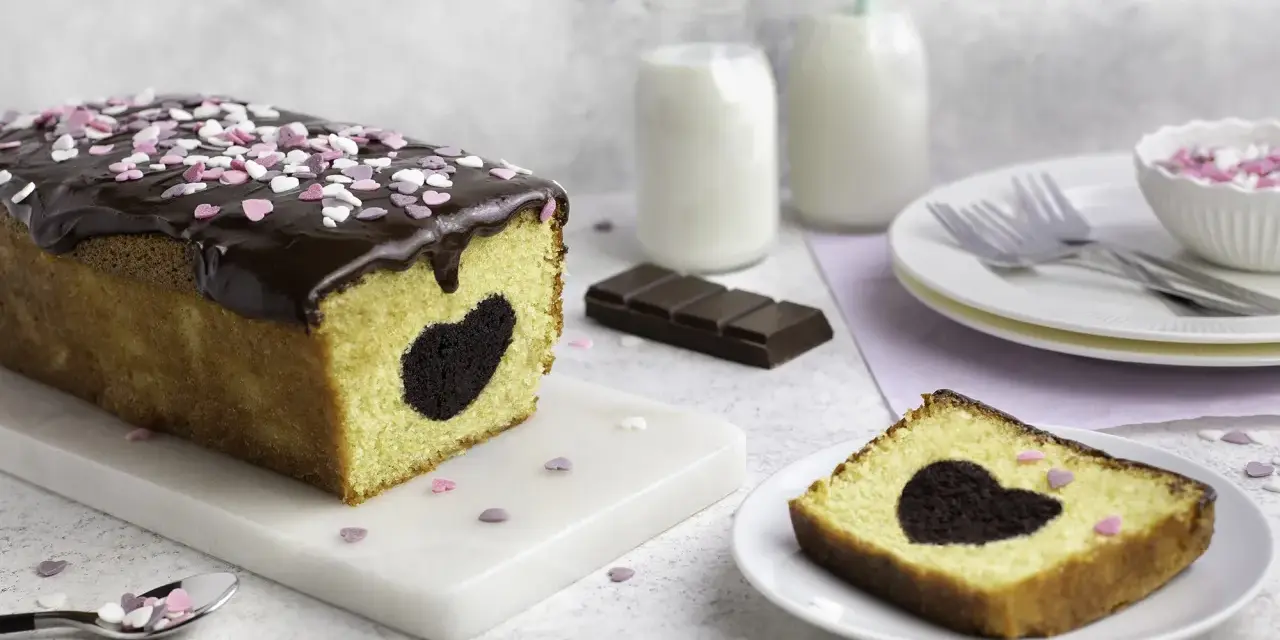 Herzförmiger Schokoladenkuchen mit Schokoladenglasur und Streuseln. Perfekt für Valentinstag Rezepte!