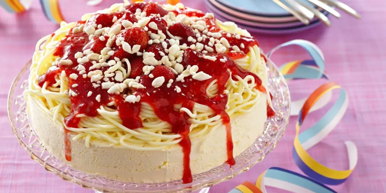 Ein lustiger Spaghetti-Eis-Kuchen mit Erdbeersoße und weißen Schokostückchen. Perfekt für jede Party!