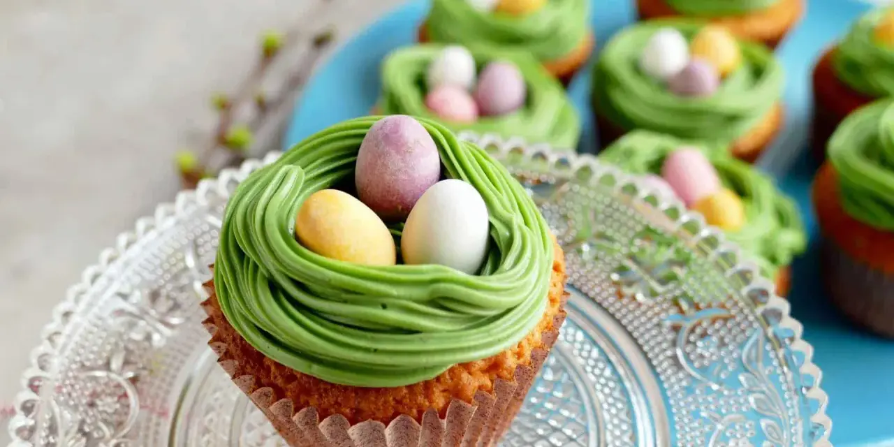 Oster-Cupcakes mit grünem Frosting als Nest und bunten Schokoladen-Eiern.