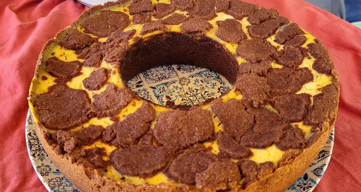 Ein köstlicher russischer Zupfkuchen mit einem Mürbeteigboden und einer cremigen Käsemasse, bedeckt mit schokoladigen Zupfen.
