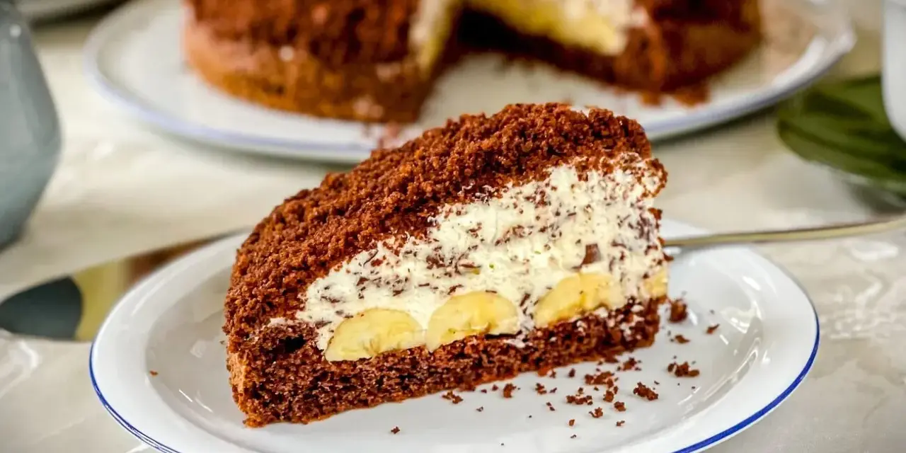 Ein Stück saftiger Maulwurfkuchen mit Bananen und Sahne. Dieses Maulwurfkuchen Rezept ist ein Genuss!