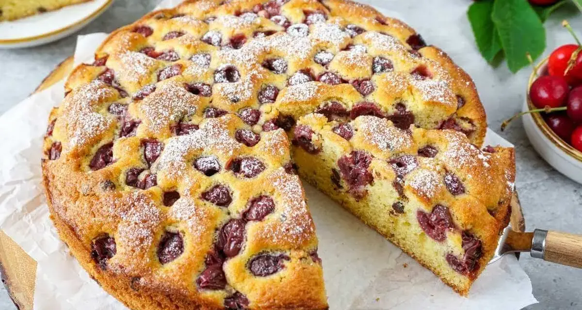 Saftiger Kirschkuchen, perfekt für ein Kirschkuchen Rezept. Mit Puderzucker bestäubt und voller Kirschen.