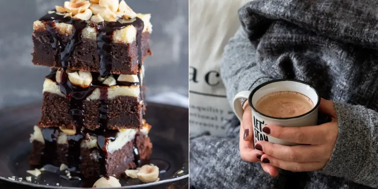 Gestapelte Cheesecake Brownies mit Schokoladenglasur und Nüssen, daneben eine Tasse Kakao.
