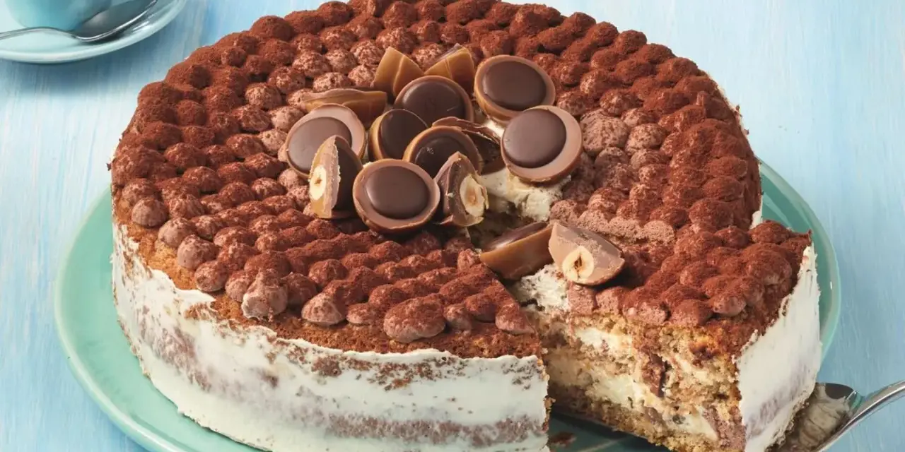 Eine köstliche Toffifee Torte, verziert mit Kakao und Toffifee-Pralinen, wird angeschnitten.