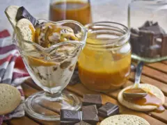 Eisbecher mit Karamellsauce, Keksen und Schokostückchen. Selbstgemachtes Karamell zum Verfeinern.