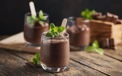 Schokoladenmousse im Glas, garniert mit Minze und Schokostückchen. Ein Genuss, der mit dem Thermomix leicht gelingt.