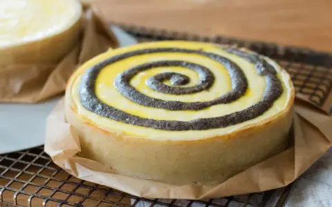 Ein köstlicher no bake cheesecake mit Mohn-Spiralen auf einem Gitter.
