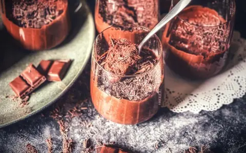 Lufterleichter Genuss: Mousse au chocolat ohne Ei, garniert mit Schokostreuseln. Ein Löffel zeigt die cremige Konsistenz.