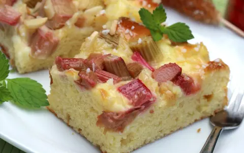 Saftiger Rhabarberkuchen mit cremiger Füllung, perfekt für Rhabarber Rezepte. Mit Minze garniert.