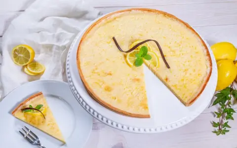 Ein Zitronentarte Rezept, das Lust auf mehr macht. Sonnengelbe Tarte mit frischen Zitronenscheiben und Minze.