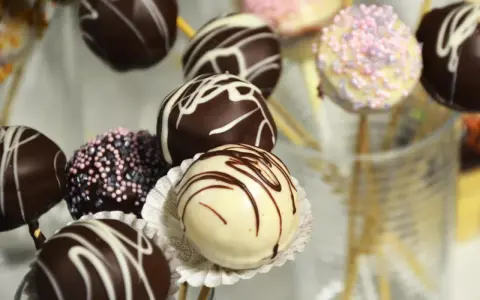 Bunte Kuchen am Stiel, dekoriert mit Schokolade und Streuseln, warten darauf, genascht zu werden.