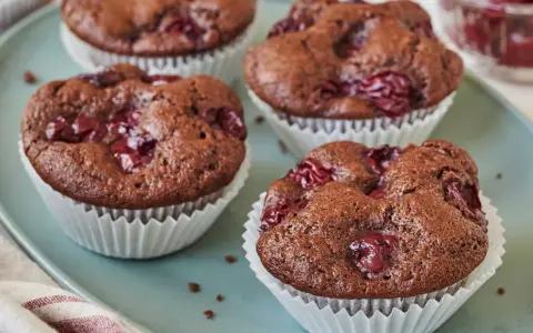 Saftige schoko kirsch muffins auf einem blauen Teller, bereit zum Genießen.